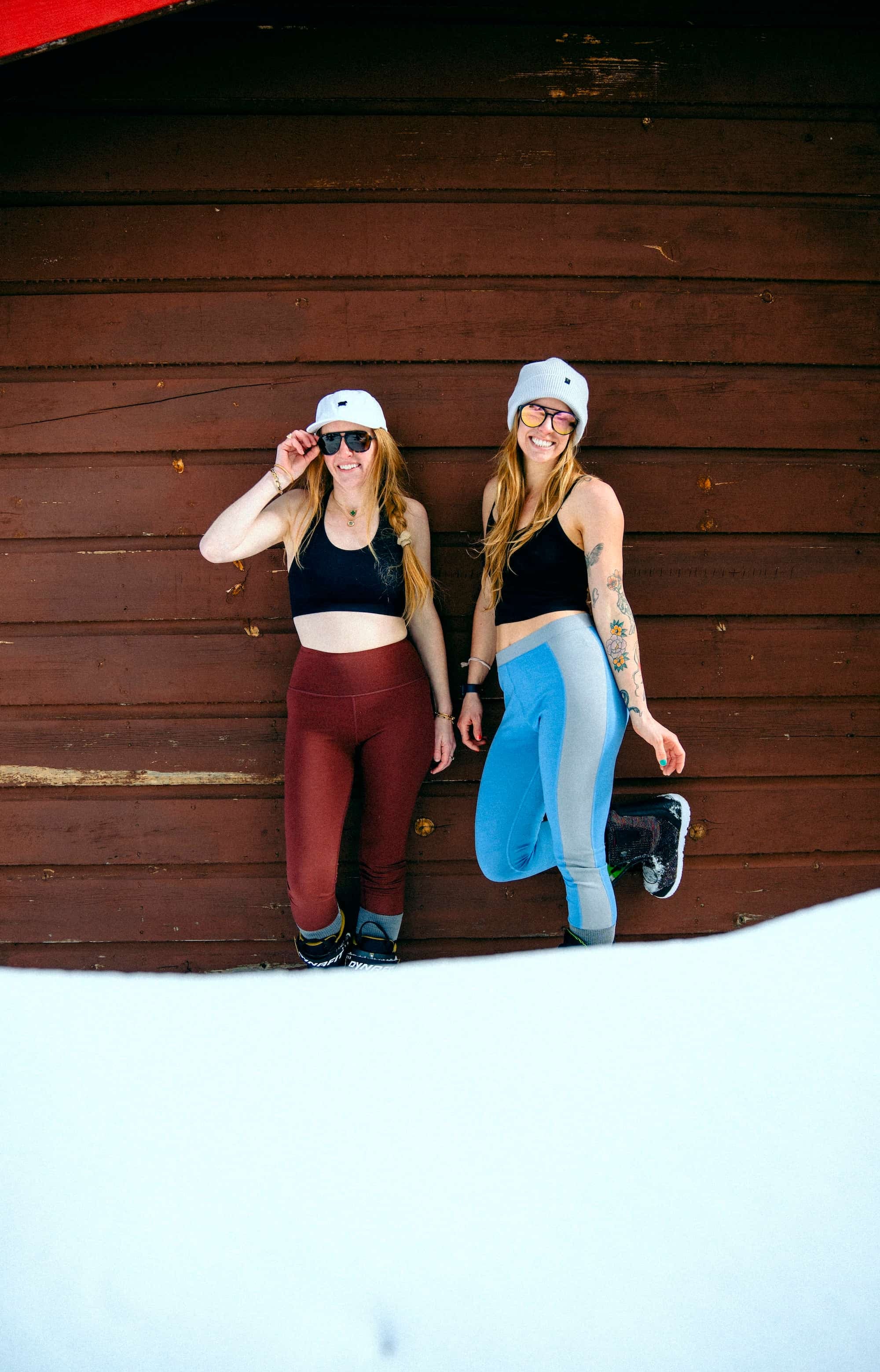 two women standing at a ski cabin in sports bras, bralettes and Ridge Merino base layers