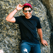 a man smiles wearing a black Journey Merino Wool T-Shirt