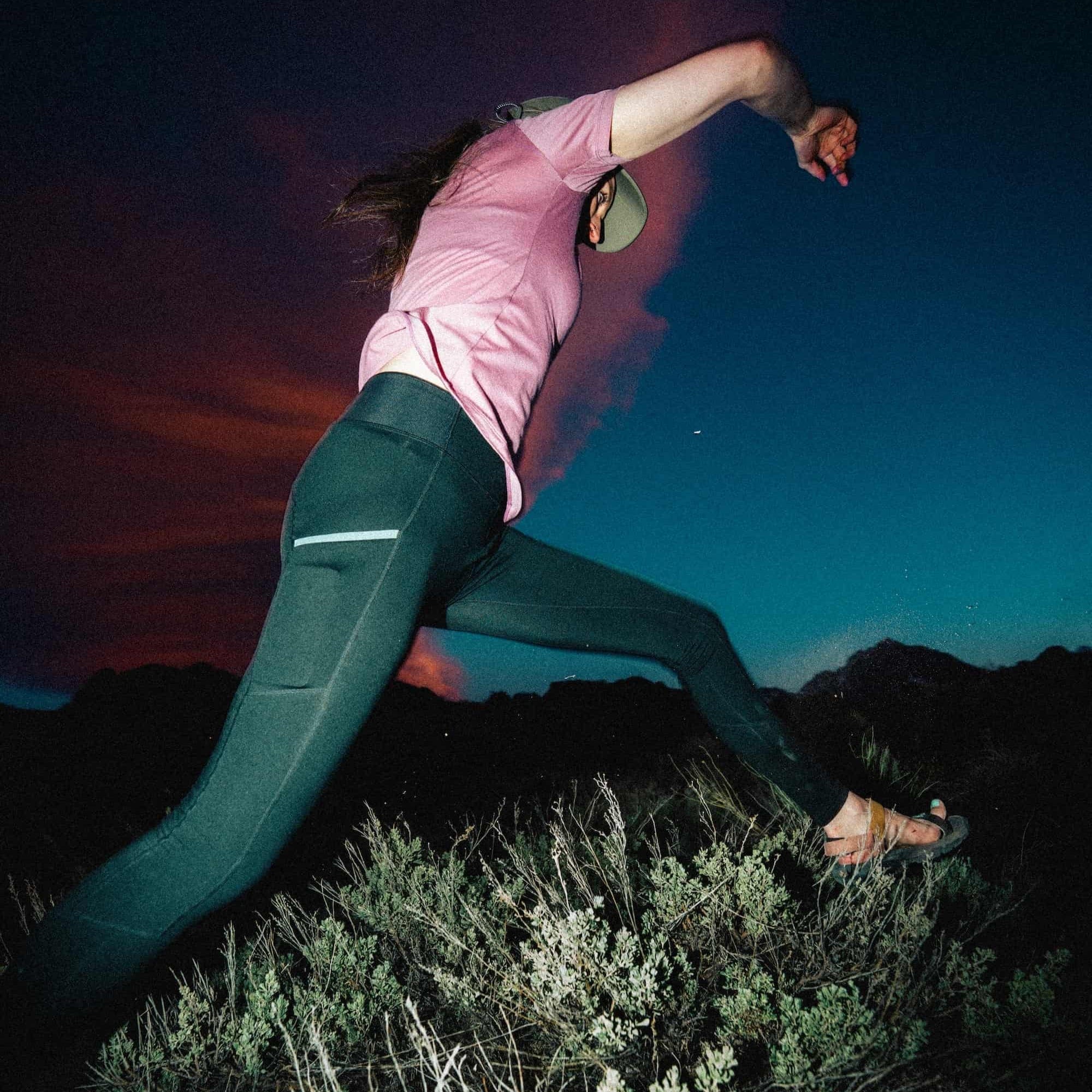 a woman jumping in Crowley Tights and a Wander V-Neck Tee