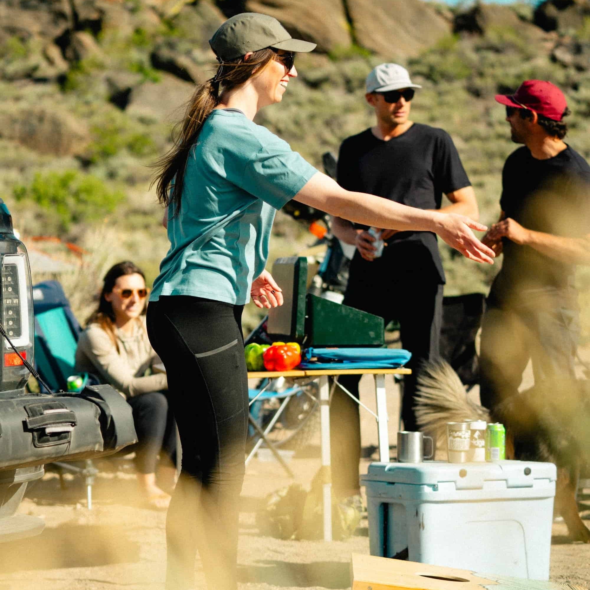 a woman playing cornhole wearing a Wander Relaxed Fit Tee in Smoke Blue