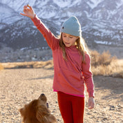 a girl wearing a Kids' Layton Merino Wool Beanie giving a treat to her dog