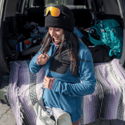 a woman zipping up her Cloudripper Grid Fleece Half Zip Mid Layer