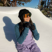 a woman zipping up her Cloudripper Half Zip Pullover in the snow