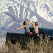 two girls hanging out of a truck wearing Ridge Merino tank tops