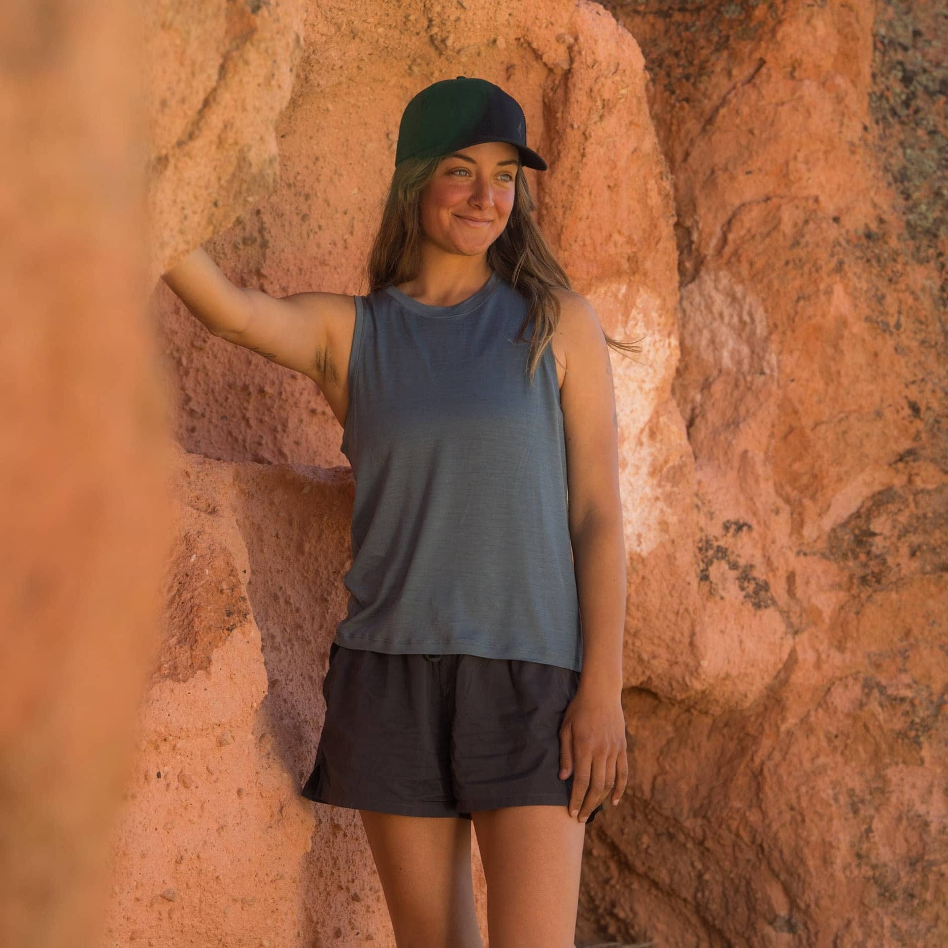 a hiker wearing a blue Canopy Merino Tencel Tank Top