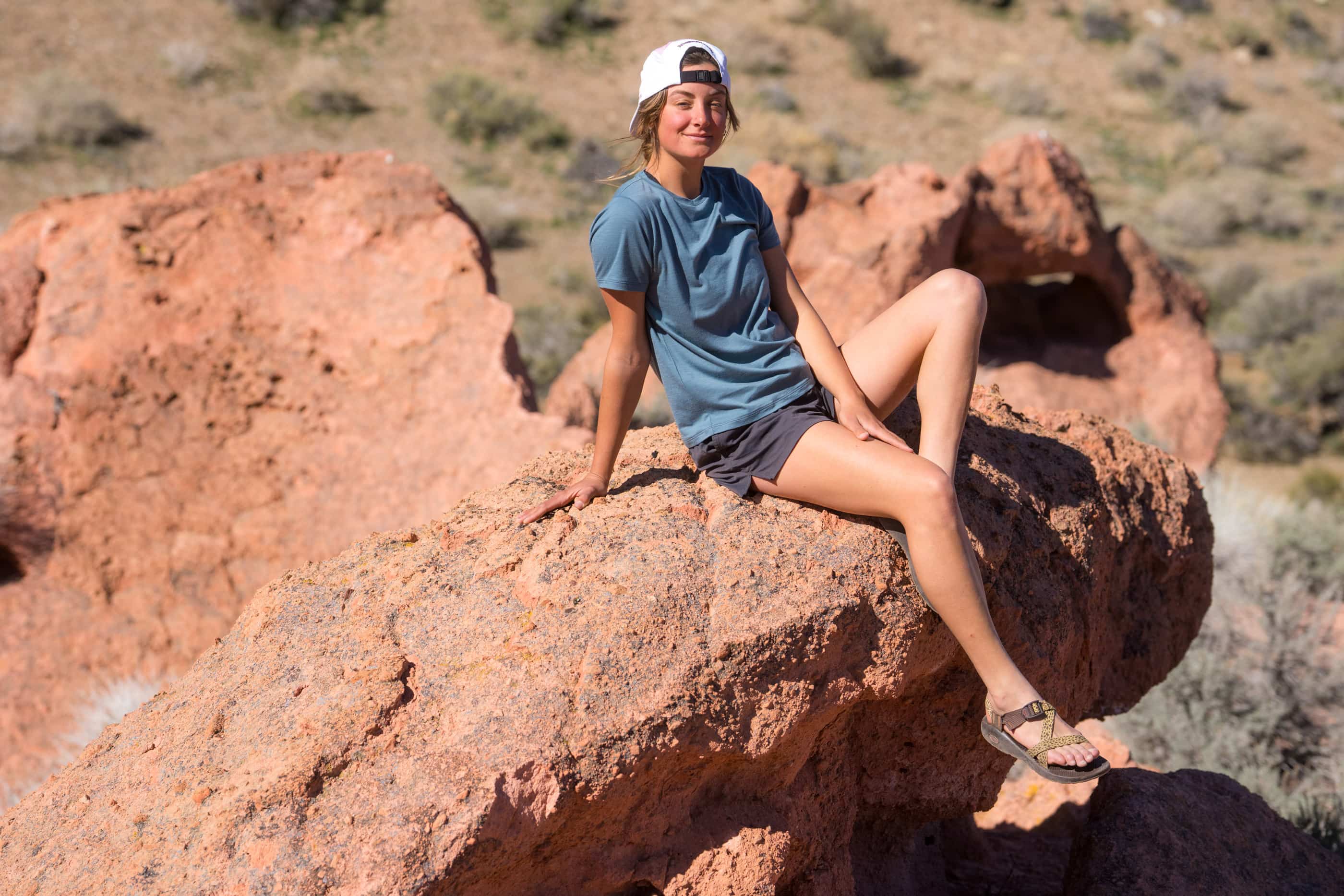 a woman sitting on a rock wearing a blue Canopy Merino Tencel T-shirt