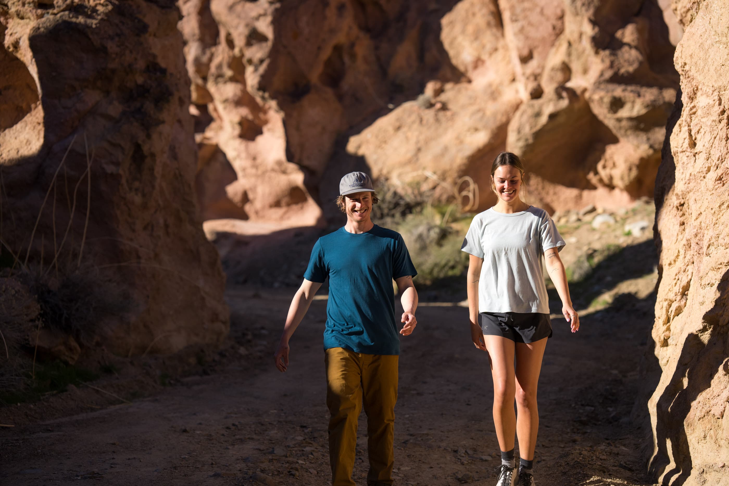 a couple walking together in a rocky canyon wearing Ridge Merino Lightweight Journey T-shirts