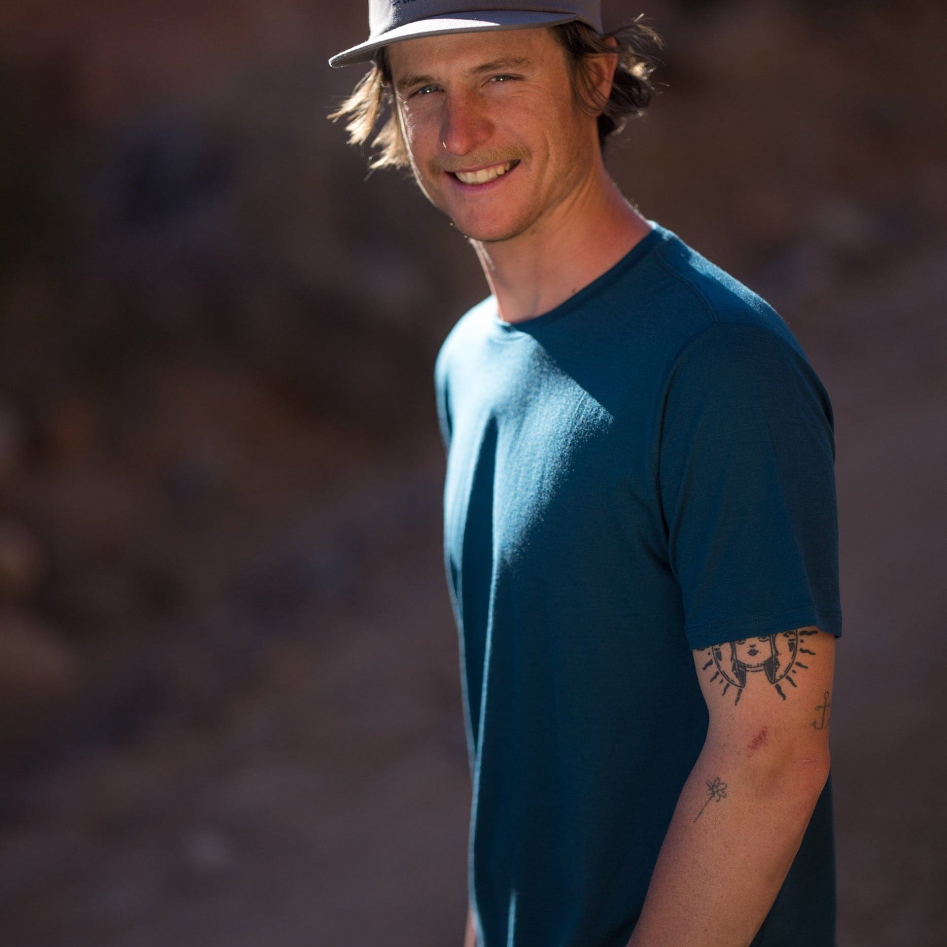 a man smiles wearing a Journey Merino Wool T-shirt in Deep Current