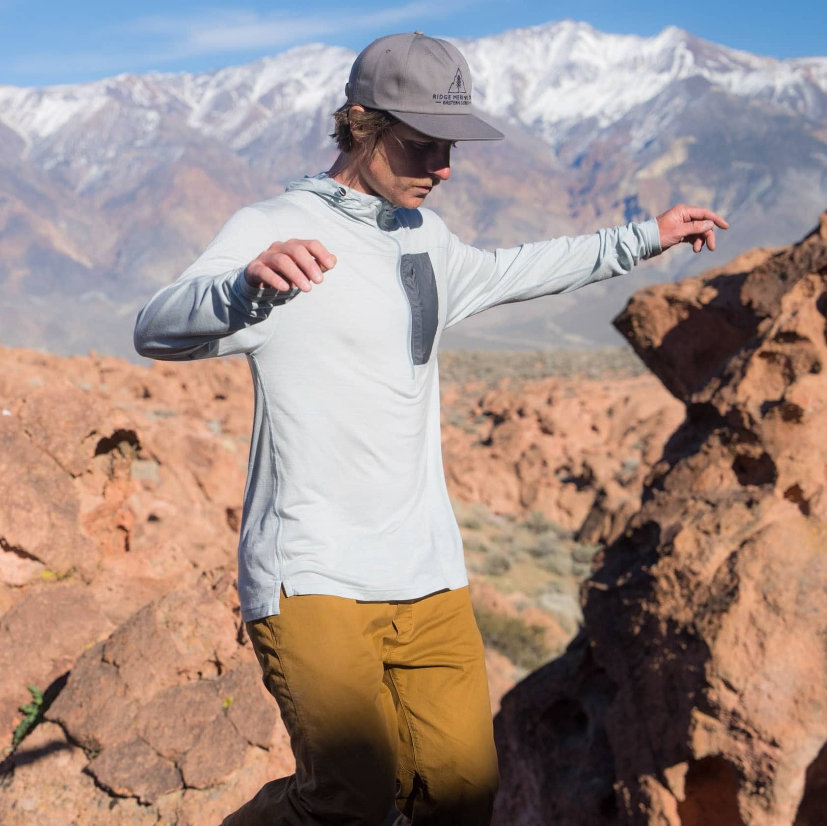 a hiker wearing an Ice Flow light blue Merino sun hoodie on a hike
