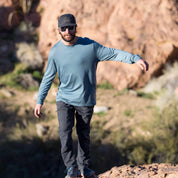 a man walking in a blue long sleeve shirt