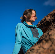 a woman wearing a teal Solstice Pro Sun Hoodie with a quarter zip and chest pocket