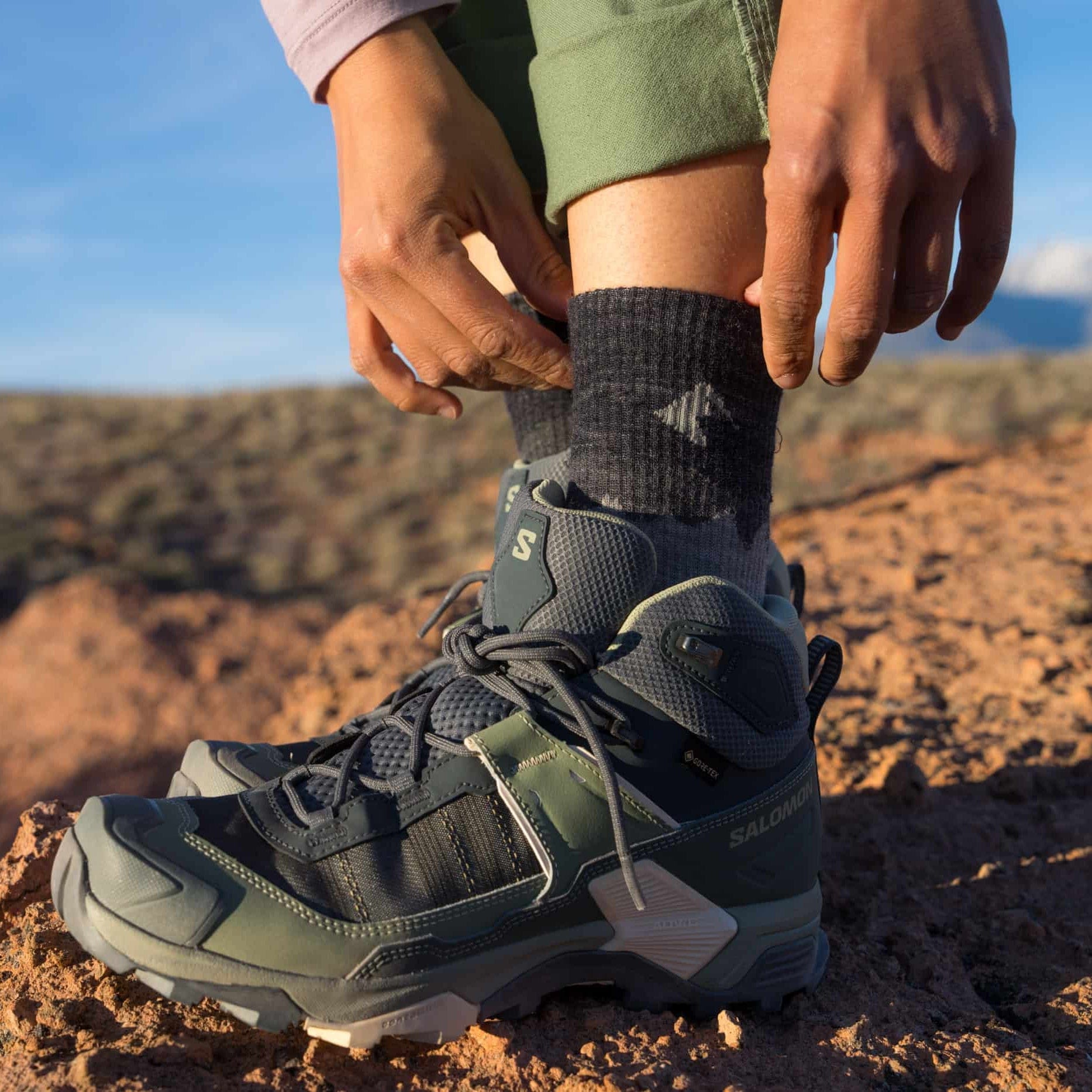 a woman wearing gray Minaret Socks with hiking boots
