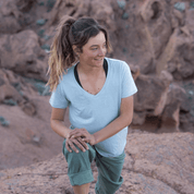 a woman stretching wearing a Merino V-Neck Shirt