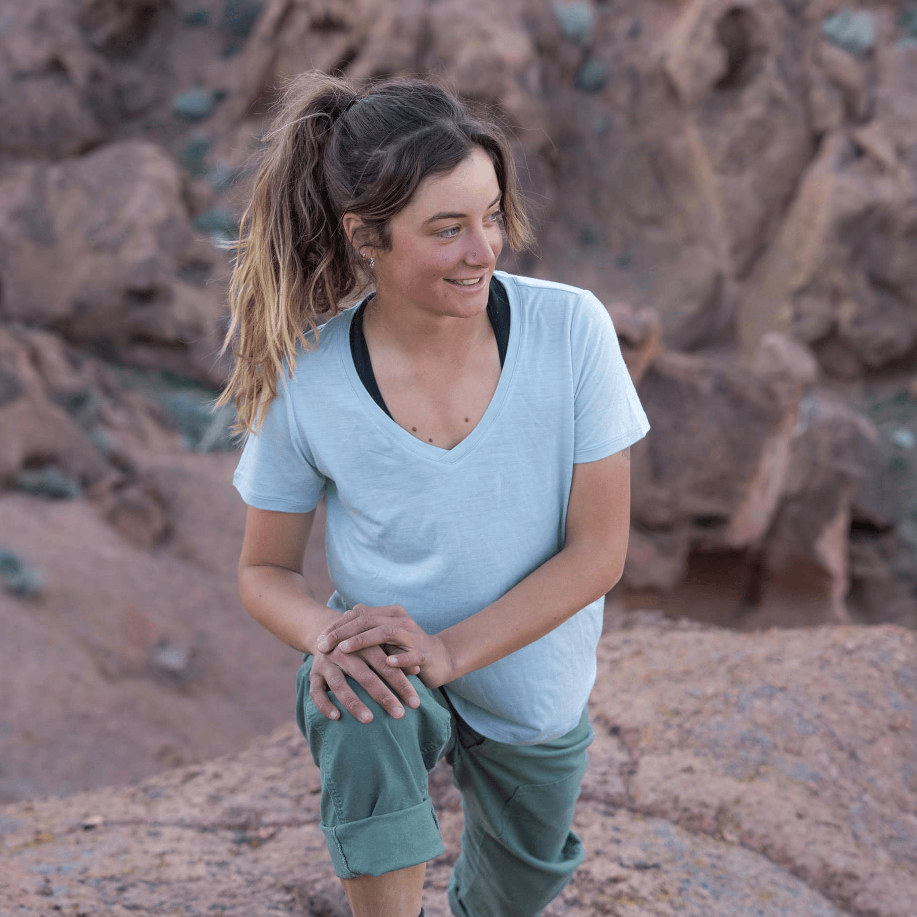 a woman stretching wearing a Merino V-Neck Shirt