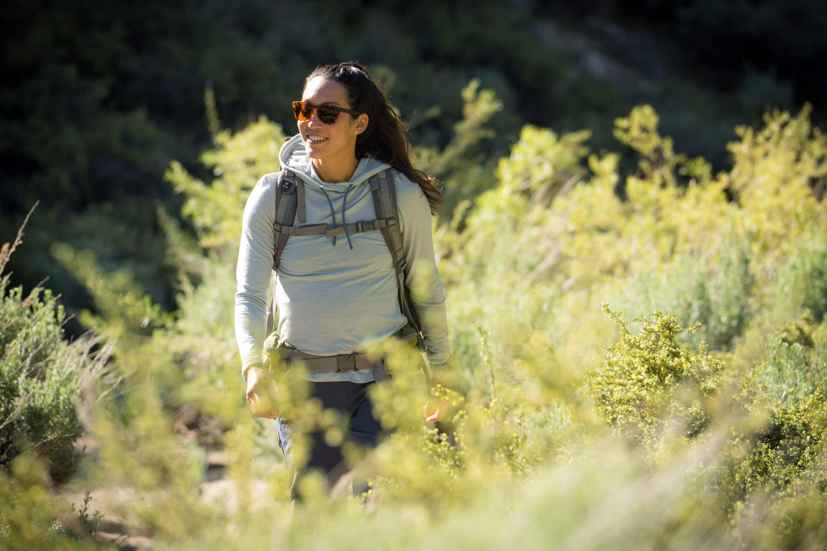 a woman hiking in a Solstice Sun Hoodie