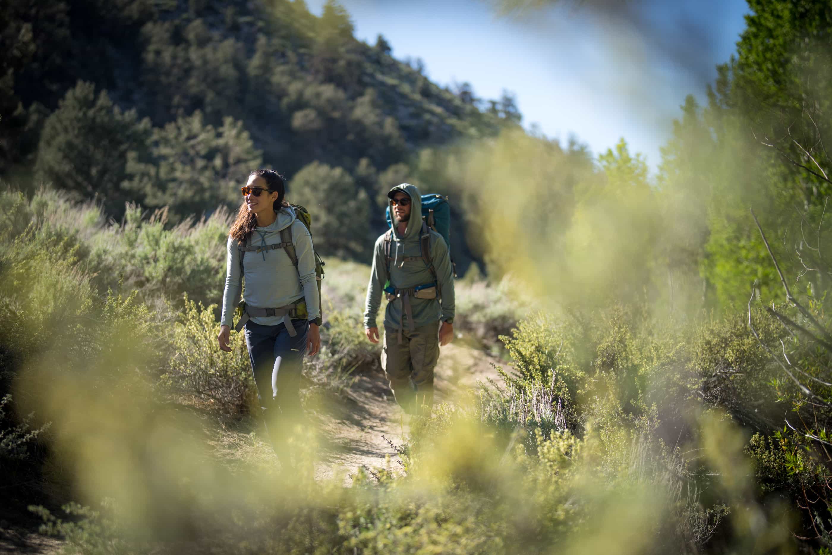 a man and a woman backpacking in Solstice Sun Hoodies