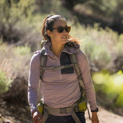 a woman hiking in a Solstice Pro Sun Hoodie