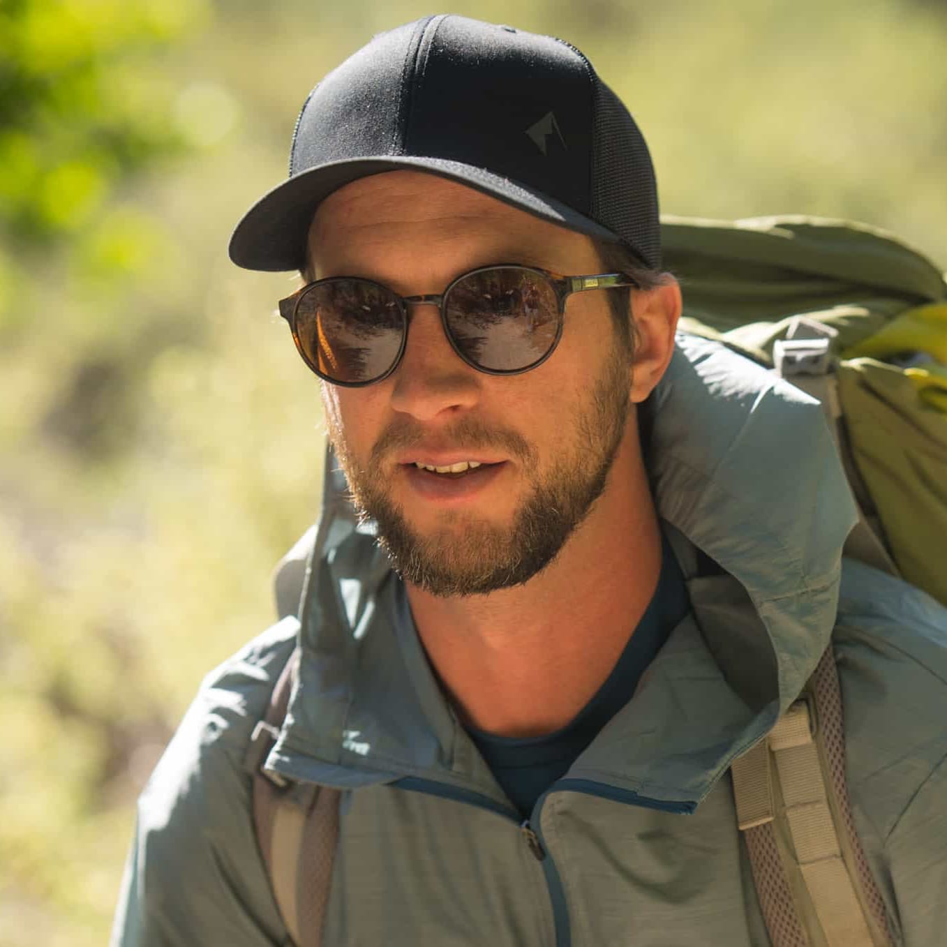 a man wearing a Windshifter Windbreaker and a Ridge Logo Hat