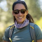 a woman smiles on a hike wearing a Sierra Merino Wool Neck Tube in Dusty Lilac