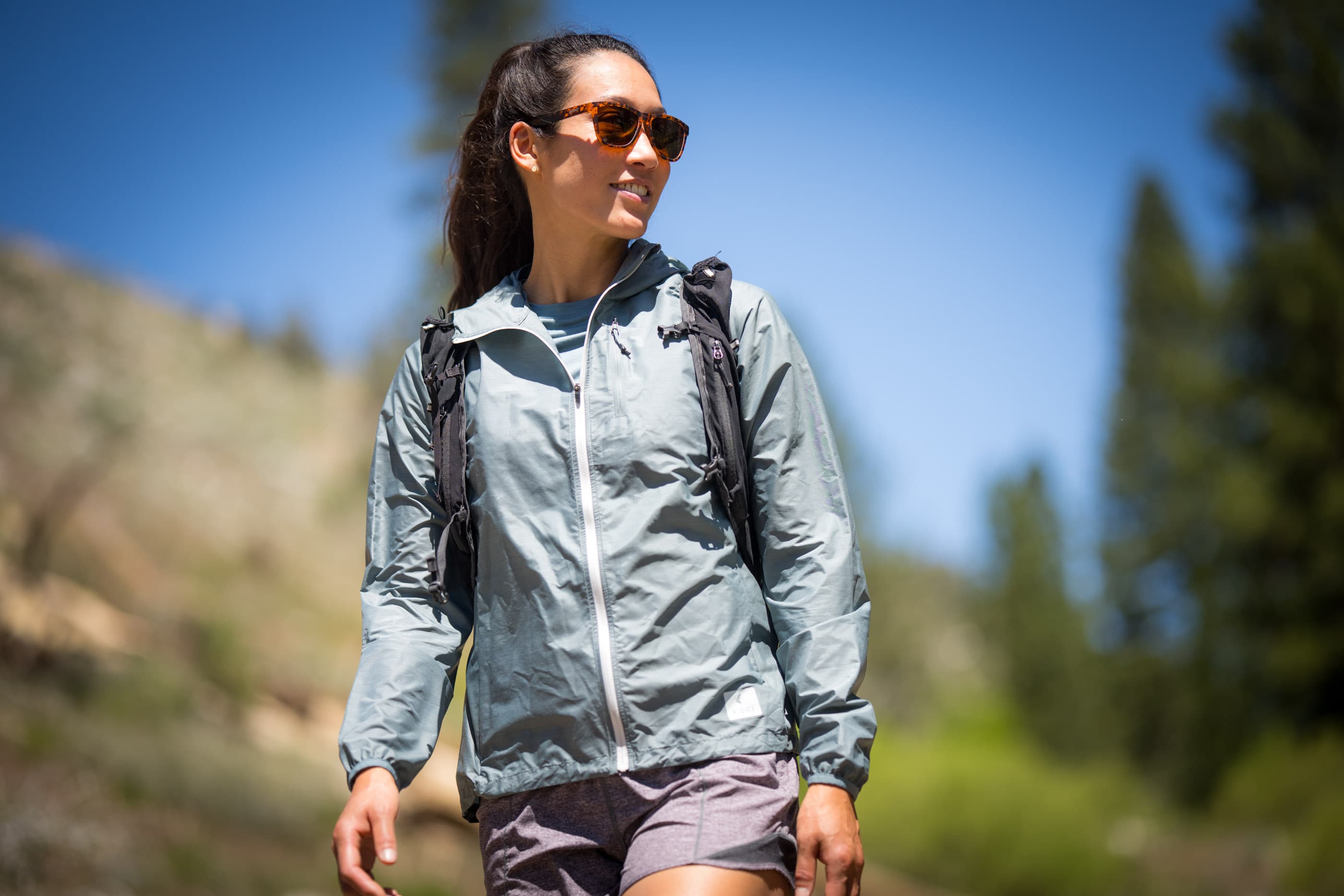 a hiker wearing sunglasses and a Windshifter Merino Windbreaker