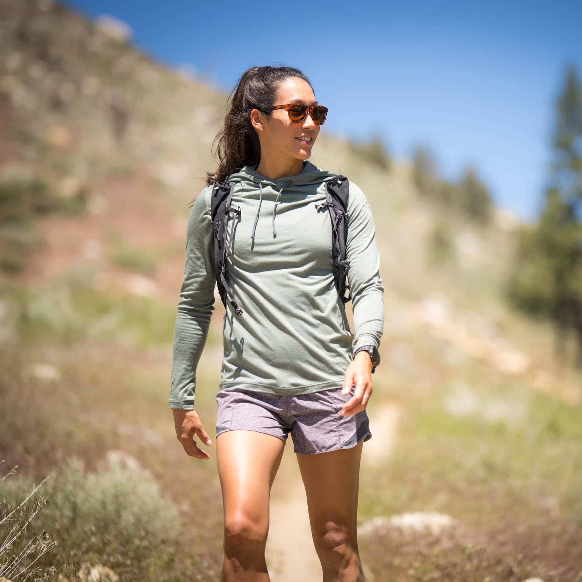 a woman hiking in a Merino Wool Sun Hoodie
