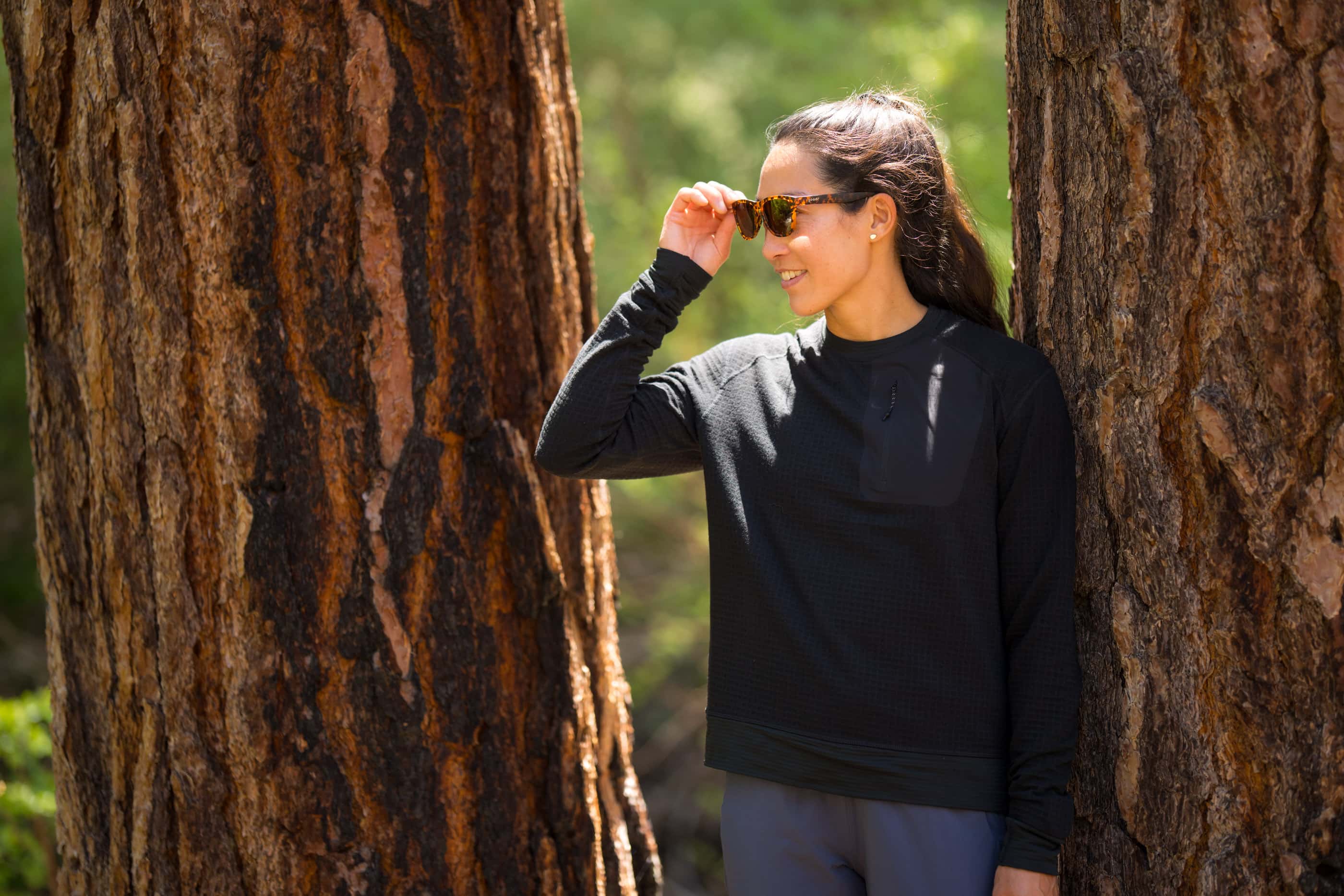 a woman wearing a Cloudripper Grid Fleece Mid Layer on a summer hike