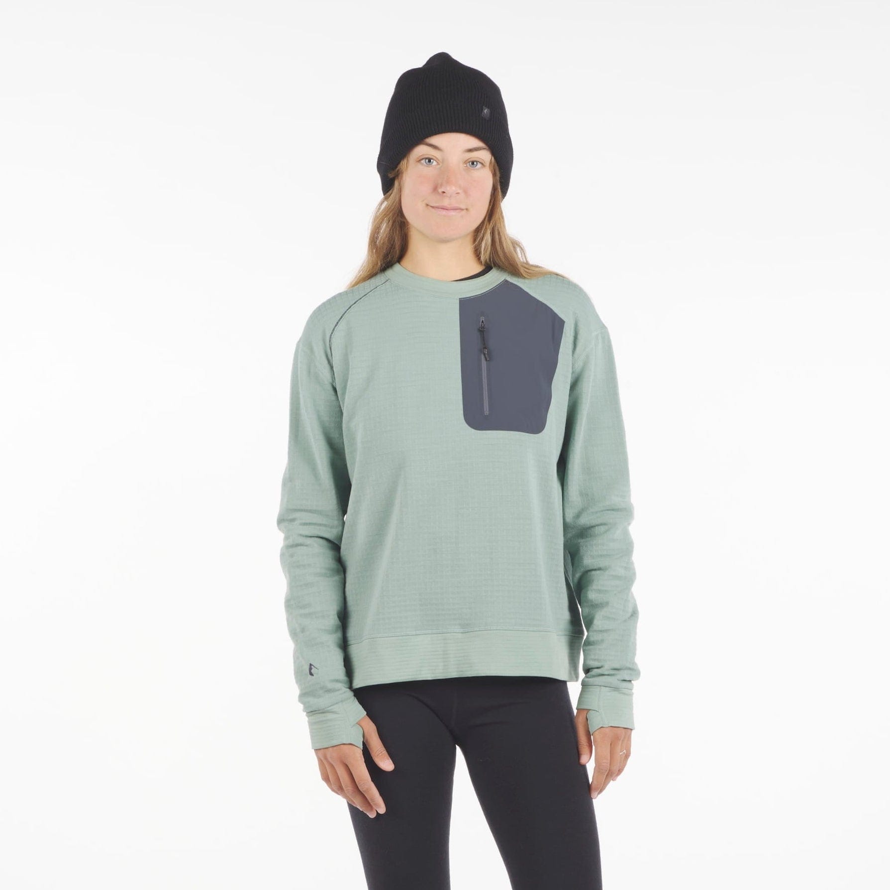 a woman wearing a Cloudripper Crew Neck Pullover in Iceberg Green with black Aspect base layer bottoms and a black Layton beanie