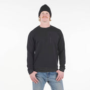 a man wearing a Cloudripper Crew Pullover in black with blue jeans and a black beanie