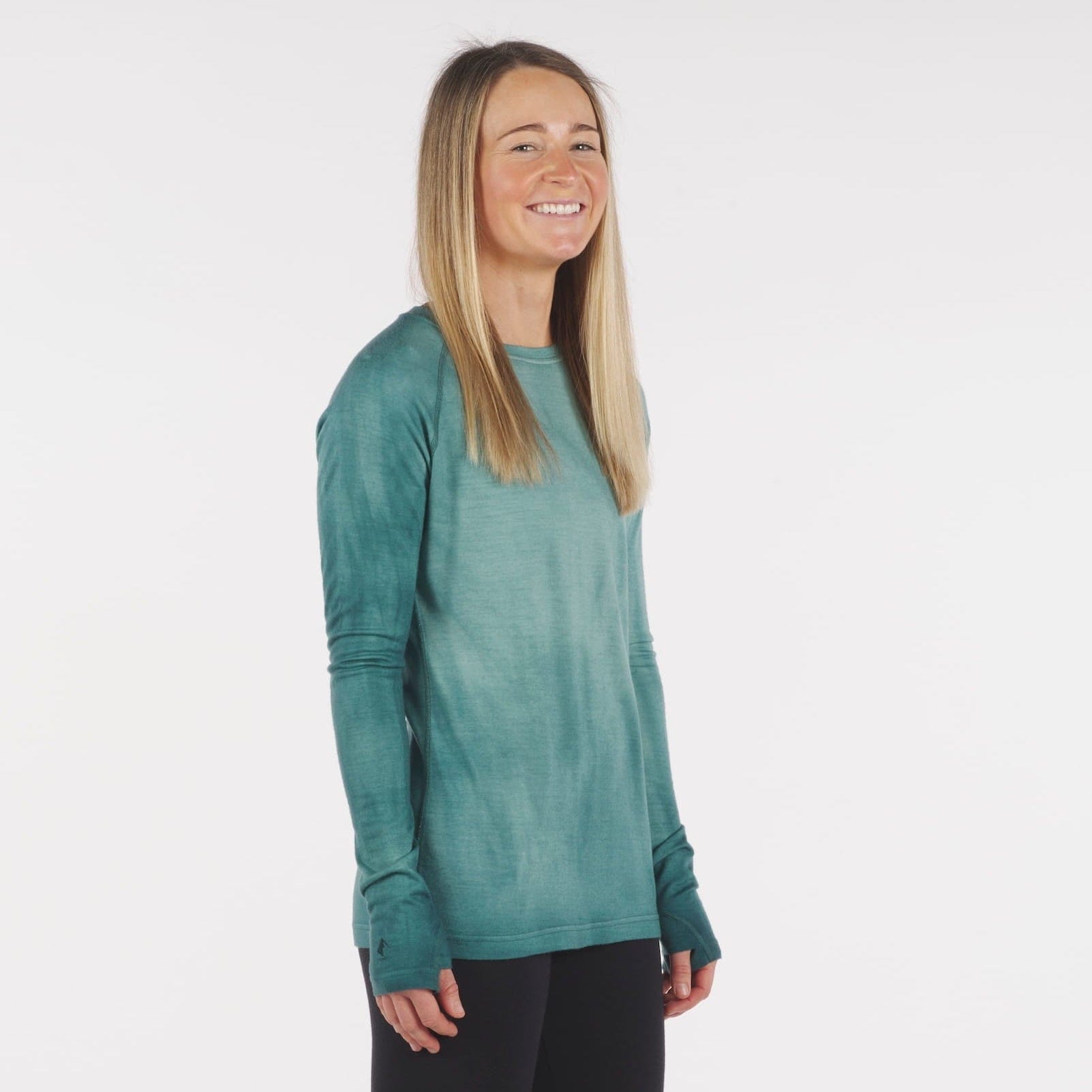 a woman wearing an Aspect Base Layer Shirt in Treetop Garment Dye