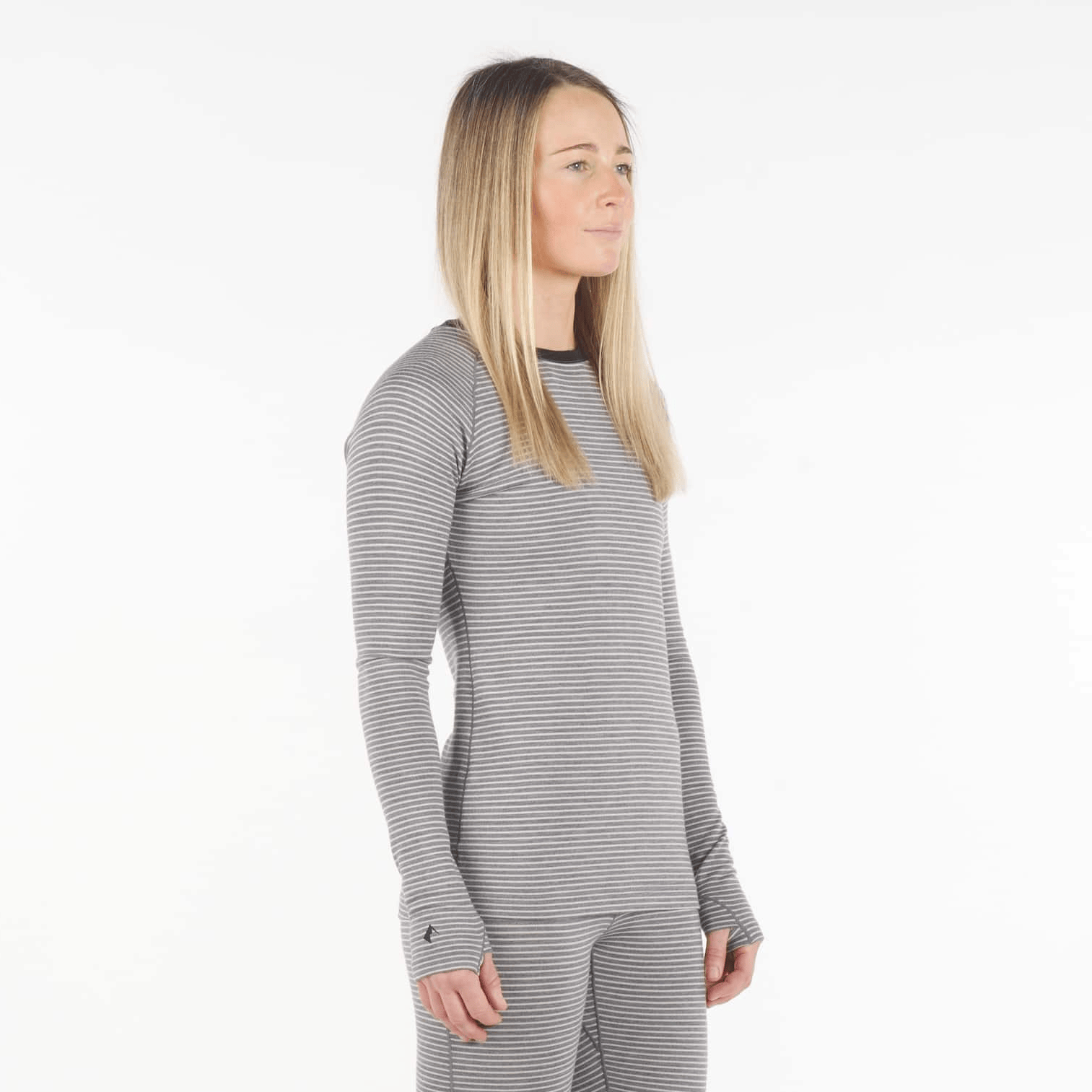 a woman wearing an Inversion base layer shirt in Bone Stripe with matching bottoms