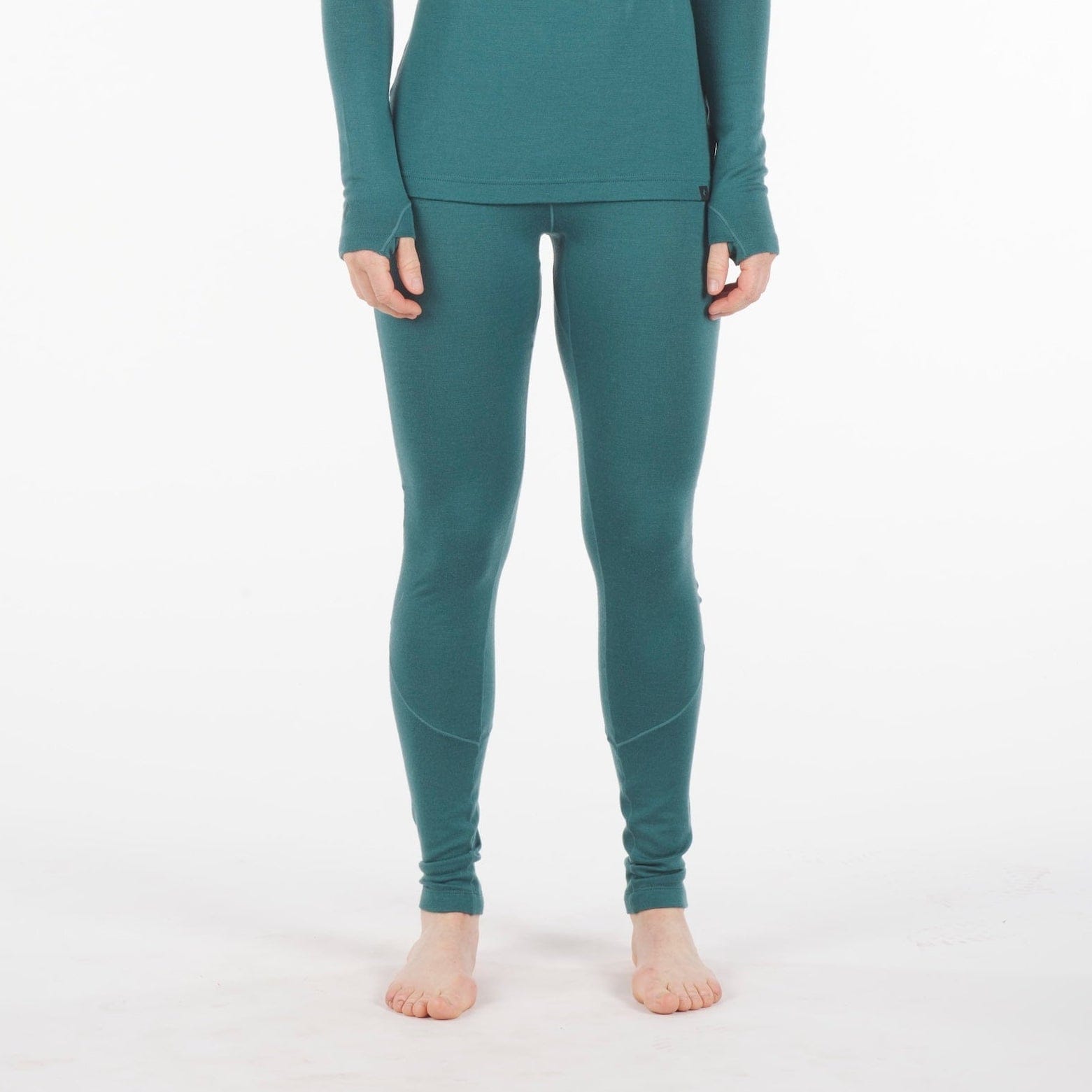 a woman wearing Inversion Merino wool bottoms in Treetop with the matching top