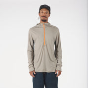 Man wearing a beige long-sleeve hoodie with an orange zipper and navy shorts on a white background