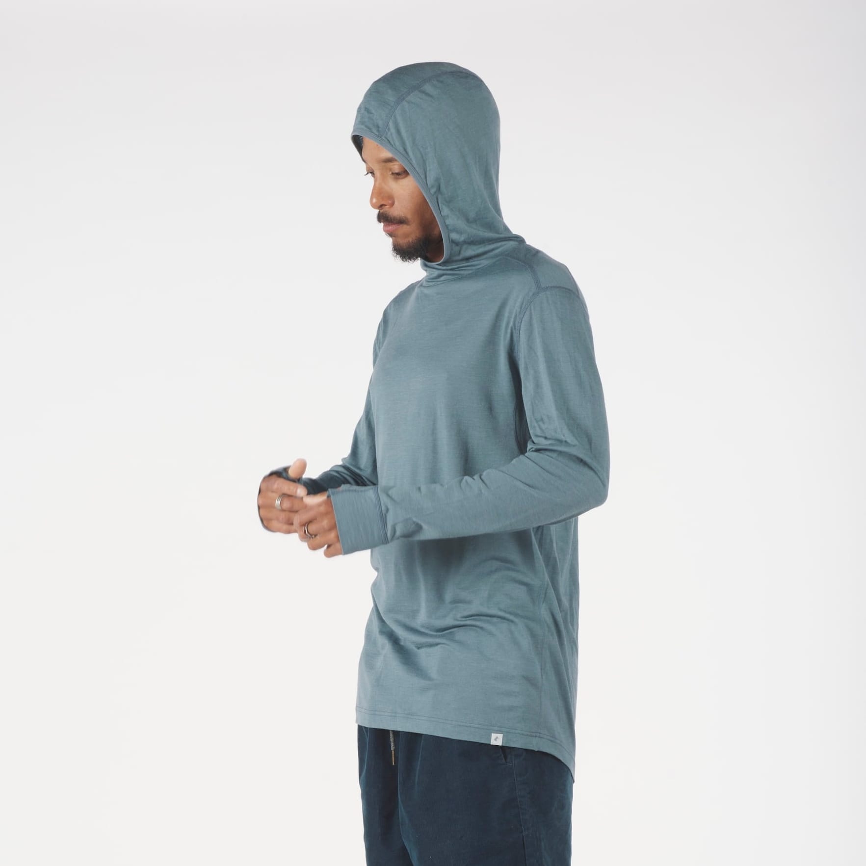 a man wearing a Ridge Merino Wool Pursuit Ultralight Hoodie in Overcast Blue