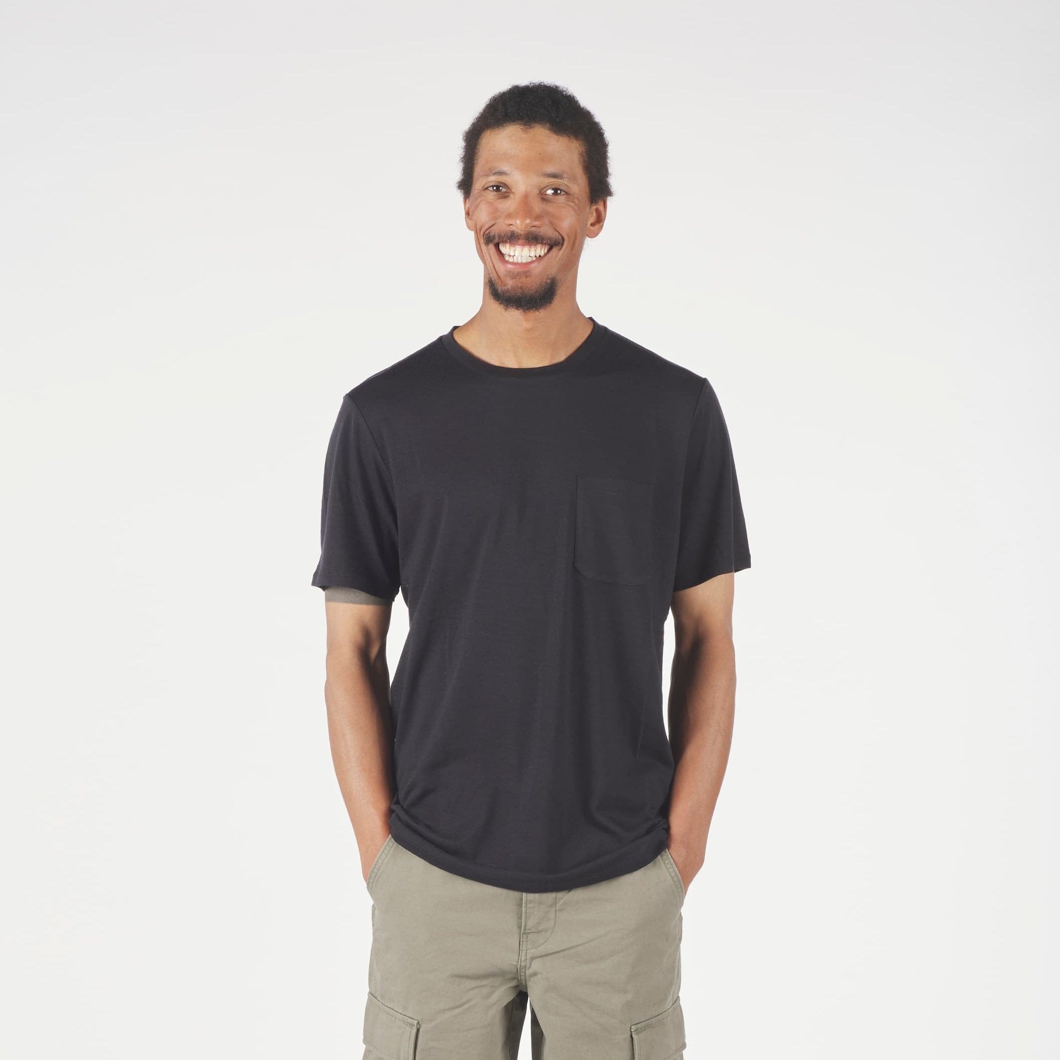 Man wearing a black t-shirt and green cargo pants on a white background