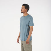 Man wearing a light blue t-shirt and beige cargo pants on a white background