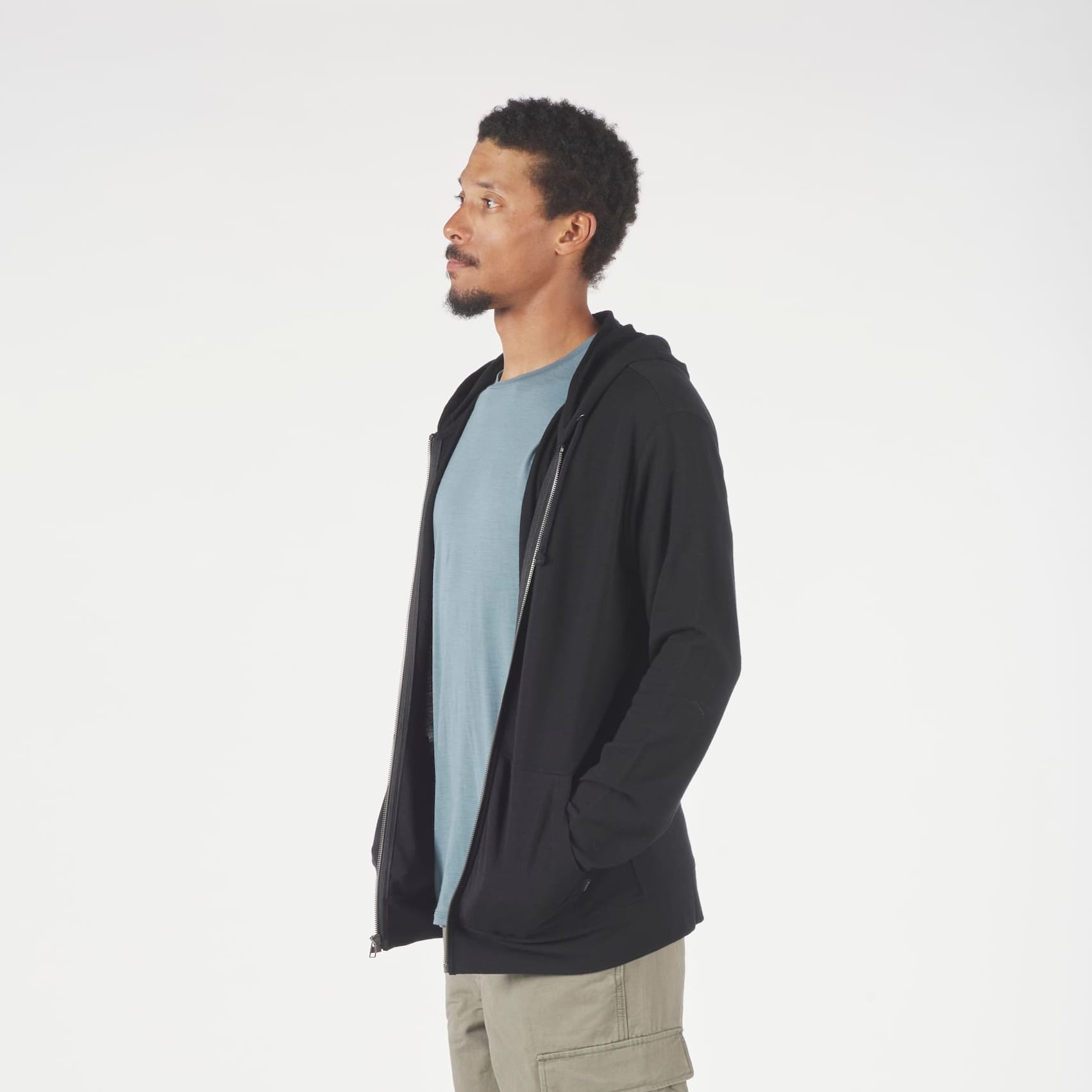 a man wearing a Ridge Merino Traveler Hoodie in black with a blue shirt underneath