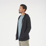 a man wearing a Ridge Merino Traveler Hoodie in black with a blue shirt underneath