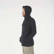 a man wearing a Ridge Merino Traveler Hoodie in black with the hood up