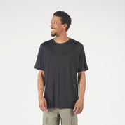 Man wearing a black t-shirt and green cargo pants on a white background