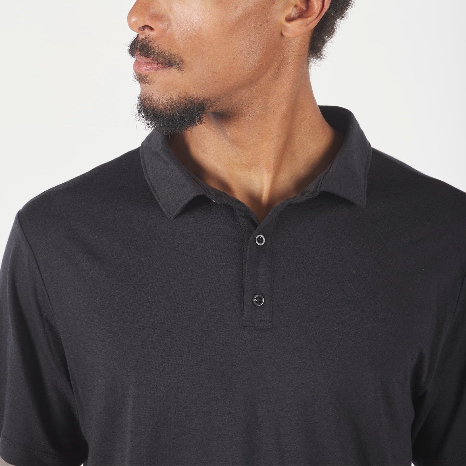 Man wearing a black polo shirt against a white background