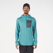 a man wearing a Solstice Pro Merino Wool Sun Hoodie in teal