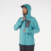 a man zipping up a Solstice Pro Merino Wool Sun Hoodie in teal