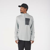 a man wearing a Solstice Pro Merino Wool Sun Hoodie in Ice Flow with a black baseball cap