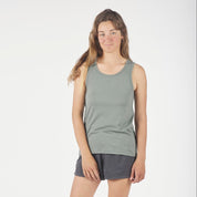 a woman wearing a green Journey Merino Wool Tank Top