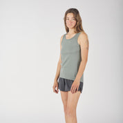 a woman wearing a green Journey Merino Wool Tank Top