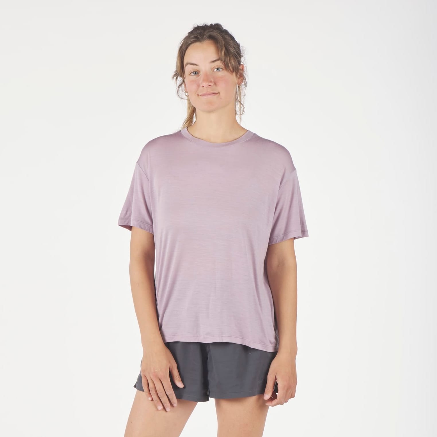 a woman wearing a Dusty Lilac Canopy Merino Tencel T-Shirt and running shorts