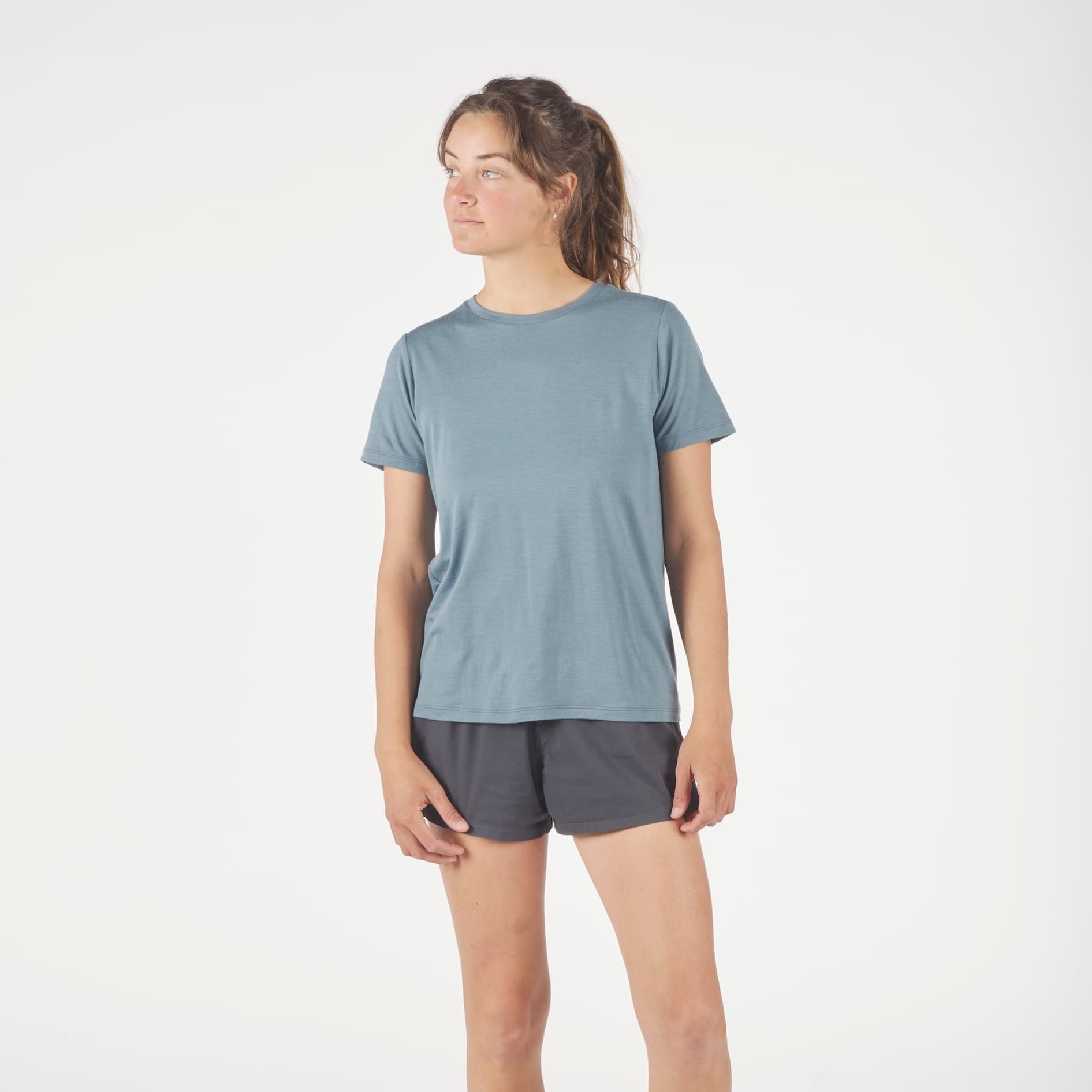 a woman wearing a Journey Crew Merino Wool T-Shirt with running shorts