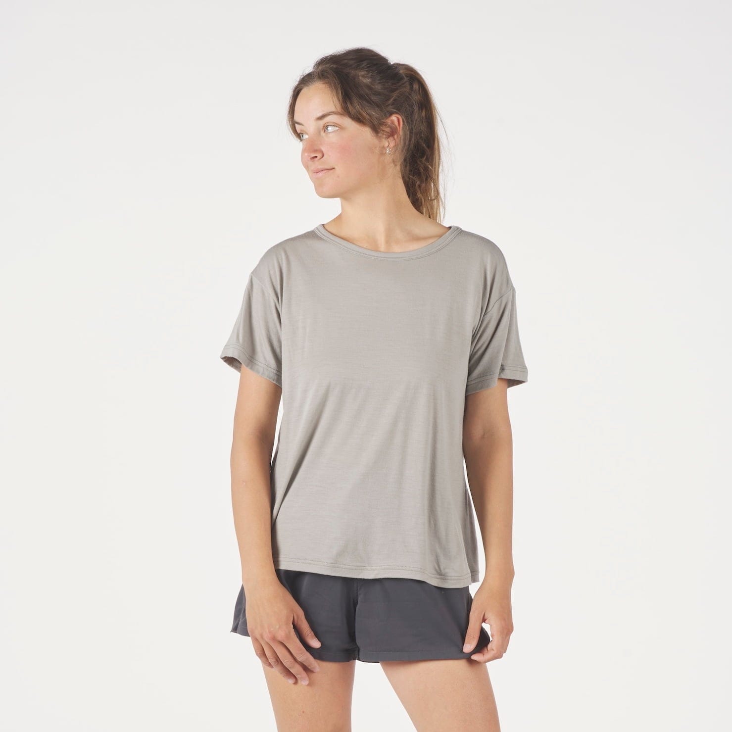 a woman wearing a Journey Merino Wool Relaxed Fit T-shirt in Rock Ridge with running shorts