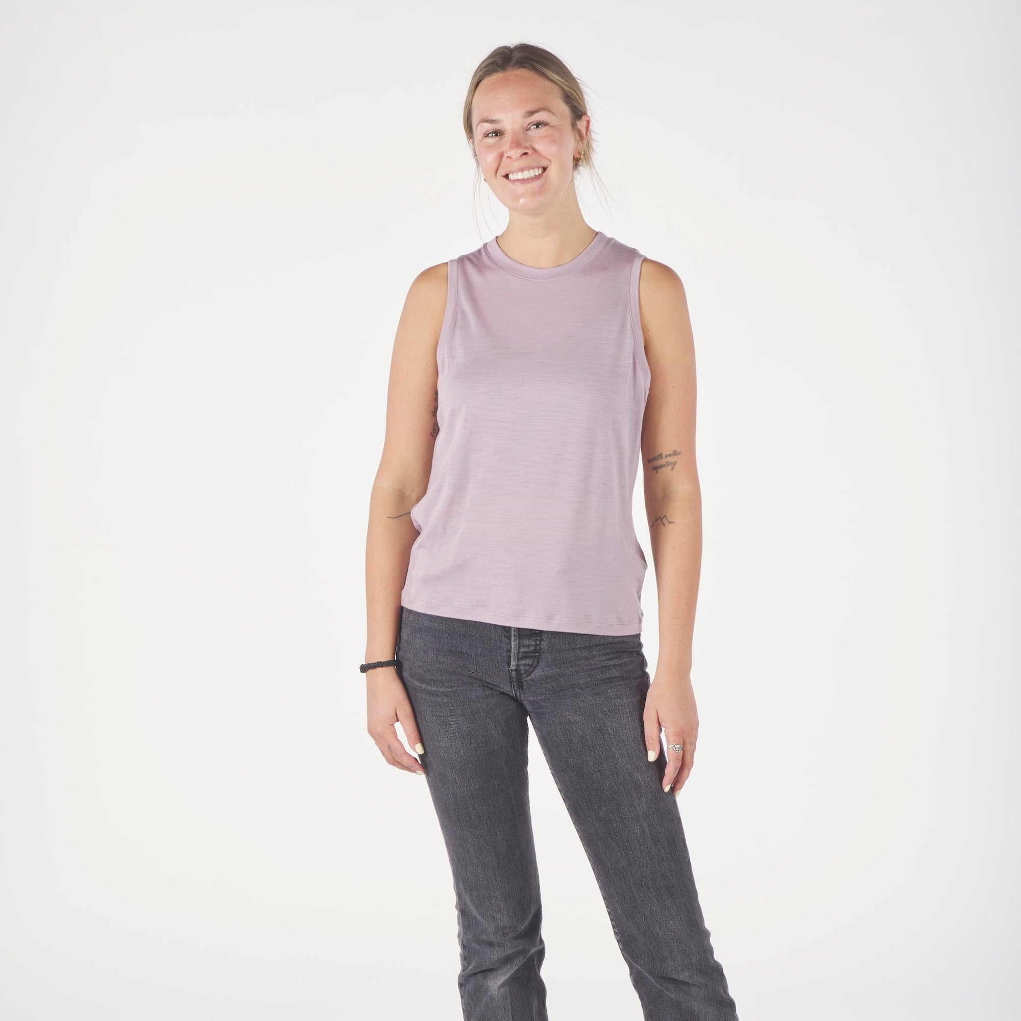 a woman wearing a pink Canopy Merino Tencel Tank Top with black jeans