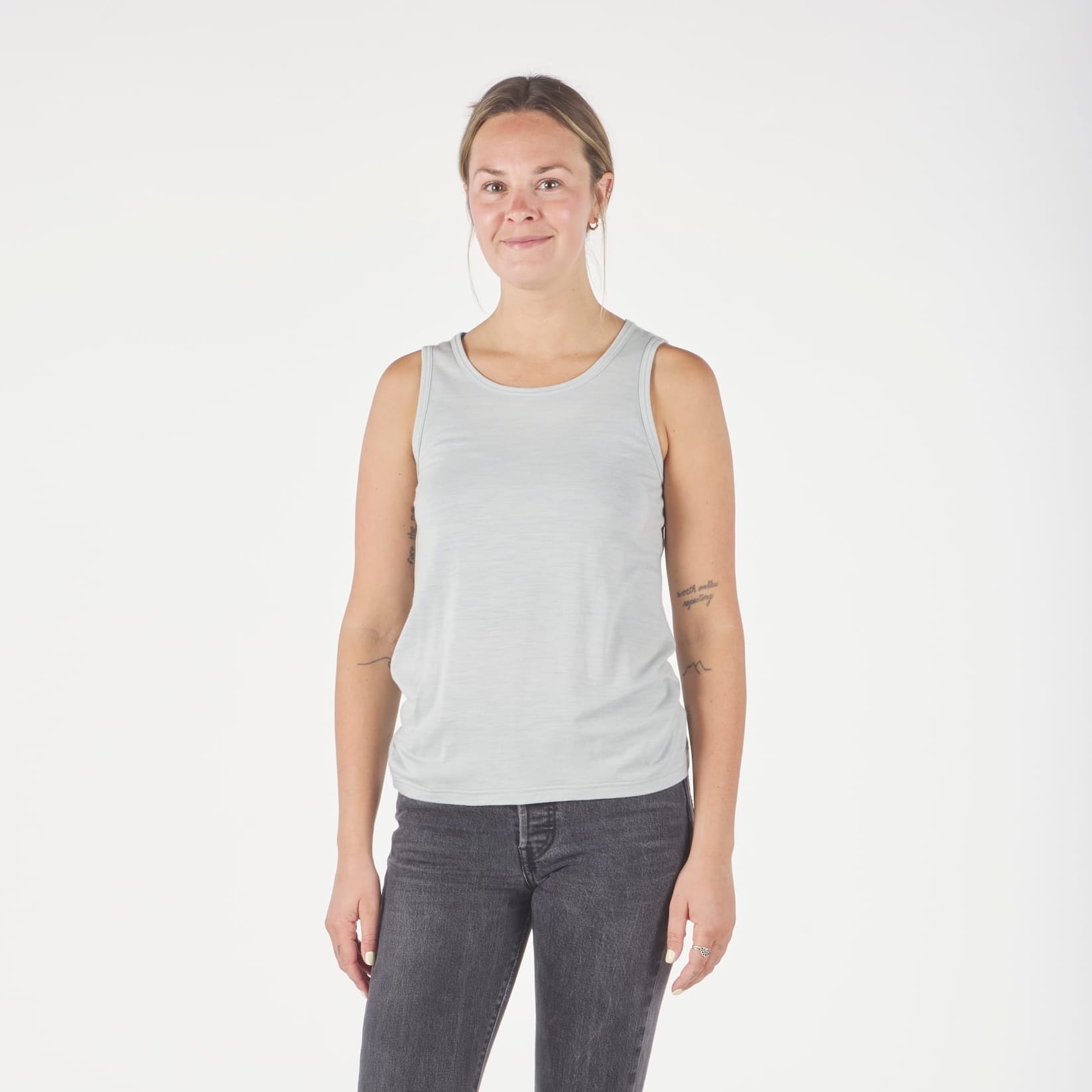 a woman wearing an Ice Flow Journey Merino Wool Tank Top